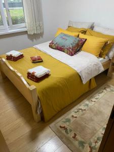 拉克塔希Vikendica Leona的黄色的床,上面有两条毛巾