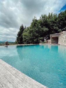 圣地亚哥－德孔波斯特拉Casa do Cebro Casa con piscina y jacuzzi privados的一座拥有蓝色海水和树木的大型游泳池
