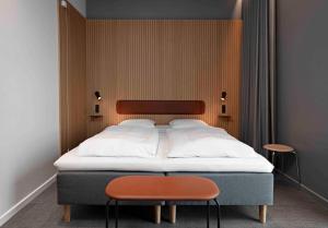霍森斯Zleep Hotel Horsens的一间卧室配有一张大床和两把椅子