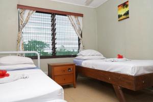 吉佐Gizo Lodge的带窗户的客房内设有两张单人床。