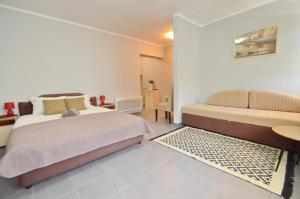 蒂瓦特Porto Lastva Apartments的一间卧室配有一张床、一张桌子和一张沙发