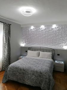 蒂沃利梅兰格罗旅馆的一间卧室配有一张大床和灰色床头板