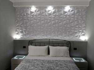 蒂沃利梅兰格罗旅馆的一间卧室,床上方有灯