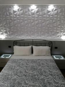 蒂沃利梅兰格罗旅馆的一张大床,上面有两个枕头,上面有灯