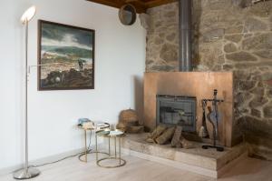 圣地亚哥－德孔波斯特拉Casa do Cebro Casa con piscina y jacuzzi privados的客厅设有石制壁炉及绘画作品