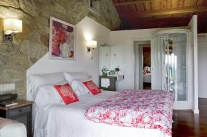 圣地亚哥－德孔波斯特拉Casa do Cebro Casa con piscina y jacuzzi privados的卧室配有带红色枕头的大型白色床