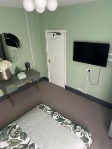 曼彻斯特Room in Manchester的一间卧室配有一张床和一台平面电视