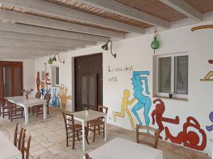 奥斯图尼B&B La casa degli artisti的墙上挂有壁画的用餐室