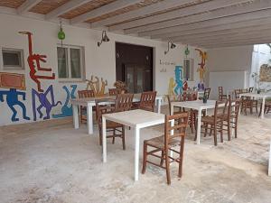 奥斯图尼B&B La casa degli artisti的一间设有桌椅的房间和一堵涂鸦墙