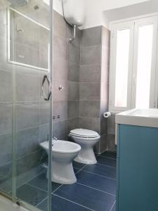 蒂沃利梅兰格罗旅馆的一间带卫生间和玻璃淋浴间的浴室