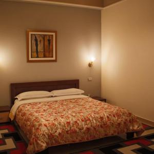 爱尔巴桑Grand Hotel的一间卧室配有一张带被子的床