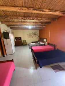 蒂诺加斯塔Munay EcoHostal - Cabañas de Adobe的大房间设有两张床和一台冰箱