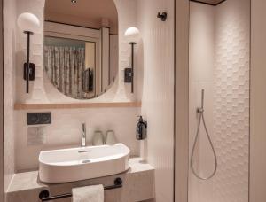 巴黎路易松酒店的一间带水槽和镜子的浴室
