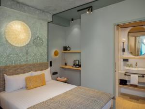 巴黎路易松酒店的一间卧室设有一张大床和一个水槽