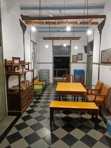 孟买瓦桑塔石兰姆孟买CST旅舍的配有桌椅和 ⁇ 格地板的房间
