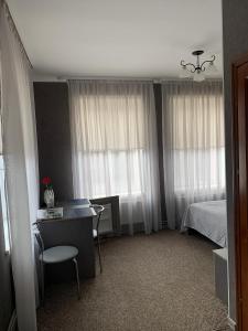 利沃夫Yurus Hostel的一间卧室配有一张床和一张桌子及椅子
