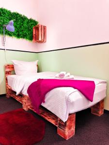 柏林Hotel Alex Berlin的一间卧室配有一张带粉色毯子的大床