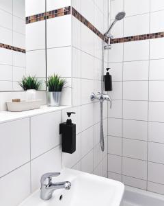 柏林Hotel Alex Berlin的带淋浴和盥洗盆的白色瓷砖浴室