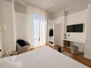 摩德纳雷齐吉公园酒店的一间卧室配有一张床、一台电视和一把椅子