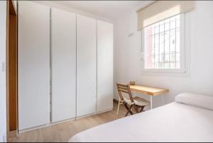 塞维利亚Acogedor y precioso apartamento en Sevilla的一间卧室配有书桌、床和窗户。