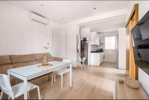 塞维利亚Acogedor y precioso apartamento en Sevilla的客厅配有白色桌子和沙发