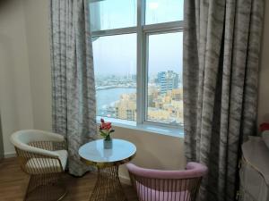 阿吉曼شقة فخمة وواسعة غرفتين luxury and big 2BR的客房设有桌椅和窗户。