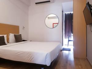 孟买Hotel Samrat, Mumbai的卧室配有一张白色大床和镜子
