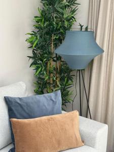 HaddenhamCountryside 2 bed cottage- Aylesbury的一张蓝色的灯,坐在一张带枕头的沙发旁