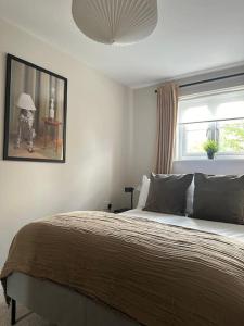 HaddenhamCountryside 2 bed cottage- Aylesbury的一间卧室配有一张床,一张带雨伞的人的照片