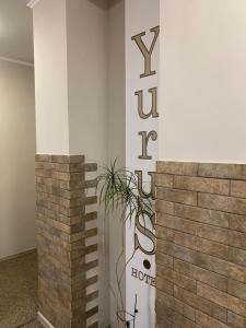利沃夫Yurus Hostel的墙上有标志和植物