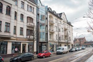 柏林Fantastic Loft with Balcony的一条繁忙的城市街道,汽车停在大楼前