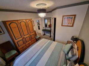 新码头The Sup Shack Wellington Inn的一间卧室配有一张大床和一把椅子