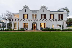 开普敦Wytham Manor House的白色的房屋,设有绿色草坪