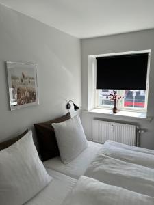 腓特烈松VISIONHOUSE Hotel的一间卧室配有两张床和一台平面电视
