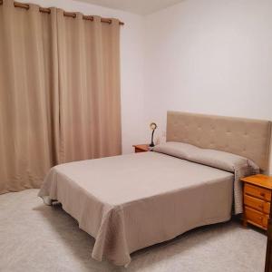 宏达海滩Casa Pancho Lanzarote的一间卧室配有床、梳妆台和窗帘