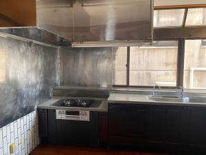 宜野湾市Joyful Rose的厨房配有炉灶和水槽