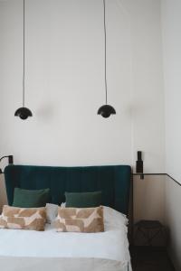 巴黎德斯贝奥克斯爱慈酒店的一间卧室,床上方有三盏灯