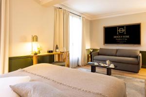 维奈Hostellerie Briqueterie & Spa Champagne的酒店客房,配有床和沙发