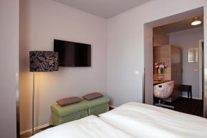 法尔肯堡单极大酒店的卧室配有一张床,墙上配有电视