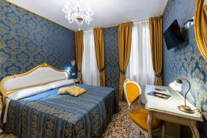 威尼斯威尼斯商人酒店的一间卧室配有一张床、一张桌子和一张书桌