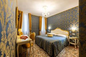 威尼斯威尼斯商人酒店的酒店客房配有一张床铺、一张桌子和一张书桌。