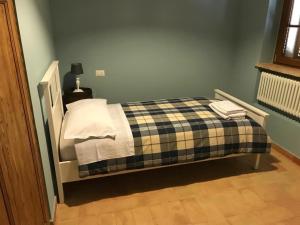 Colle San LorenzoAntico Casale San Lorenzo的一间卧室配有一张带铺着平底毯的床