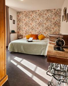 ChanteugesAuberge de Chanteuges的一间卧室配有一张带花卉墙壁的床