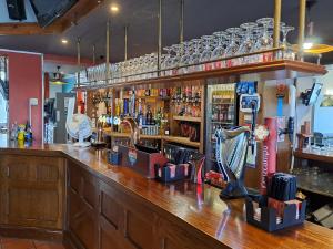 沃勒西Sheridans Budget Accomodation的酒吧设有木台面和酒吧