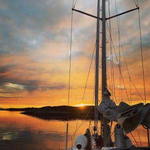 哈尔斯塔Weekend liveaboard sailing tour的水中的小船,背面是日落