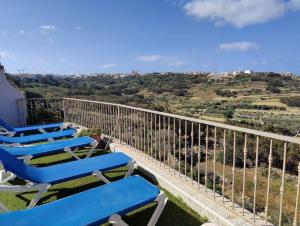 沙拉Modern Home - Valley view Pool的阳台配有蓝色椅子,享有山丘美景