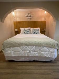 里约热内卢Cinque Terre Pousada & Bistrô的卧室配有一张带两个枕头的大白色床