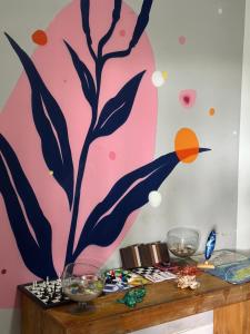 费尔南多 - 迪诺罗尼亚Coral azul Noronha的一间墙上挂有绘画的桌子的房间