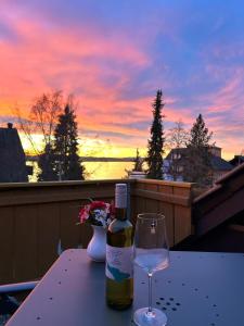 乌尔丁根-米赫尔霍芬Gästehaus Herzog的一瓶葡萄酒和一张桌子上的玻璃杯,享有日落美景