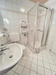 乌尔丁根-米赫尔霍芬Gästehaus Herzog的带淋浴和盥洗盆的白色浴室